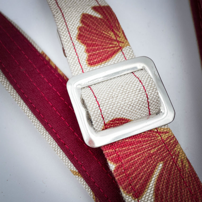 A phone-purse made from camel colored leather and a red Ginkgo Biloba leaves patterned polycotton canvas.