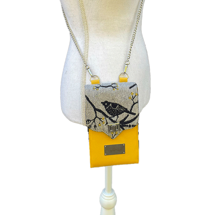 A phone-purse made from a gray, navy blue, and yellow babywearing scarf with bird motifs, and sun-yellow faux leather.