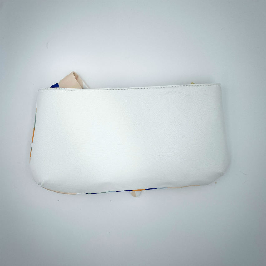 A small zippered pouch sewn in white faux leather and a colorful neck scarf with an abstract and modern flowery design in white, blue, sage, beige and cinammon. Inside is a light sage shiny poplin.
