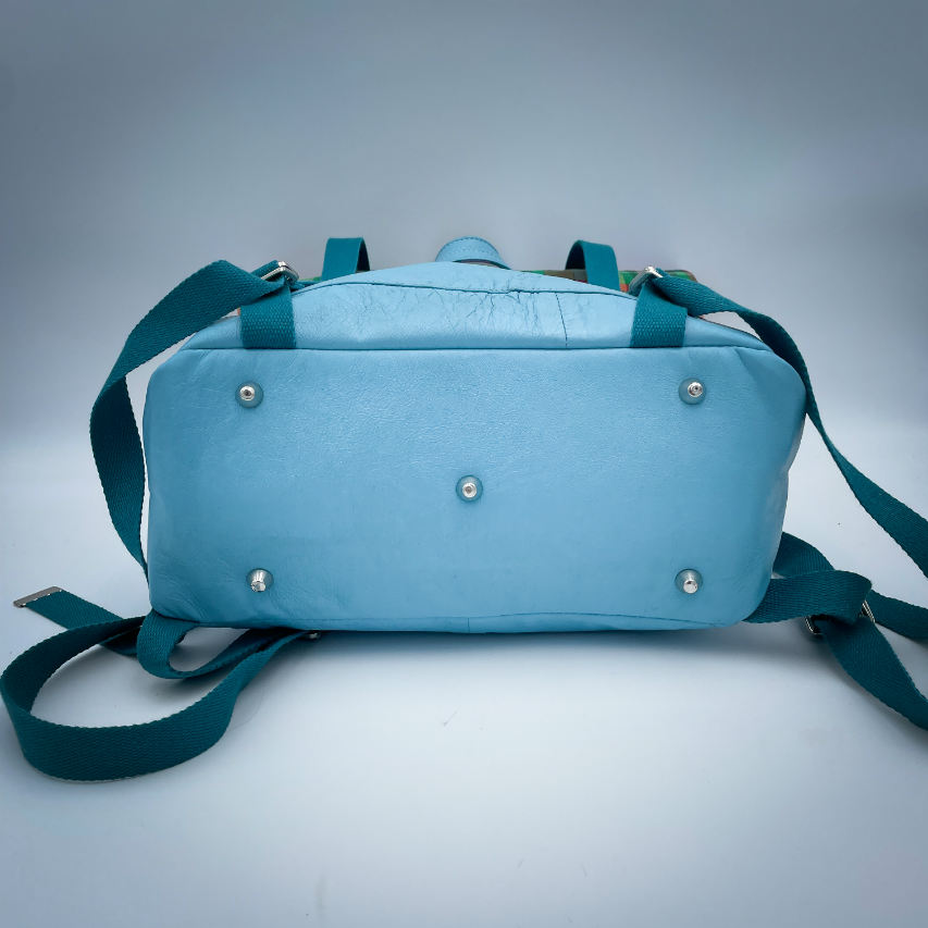 A rucksack made of light turquoise blue leather and multicolored Madras fabric.