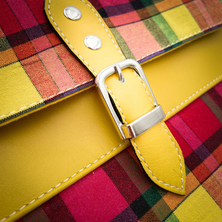 A satchel made of blood-red faux leather and multicolored madras fabric.