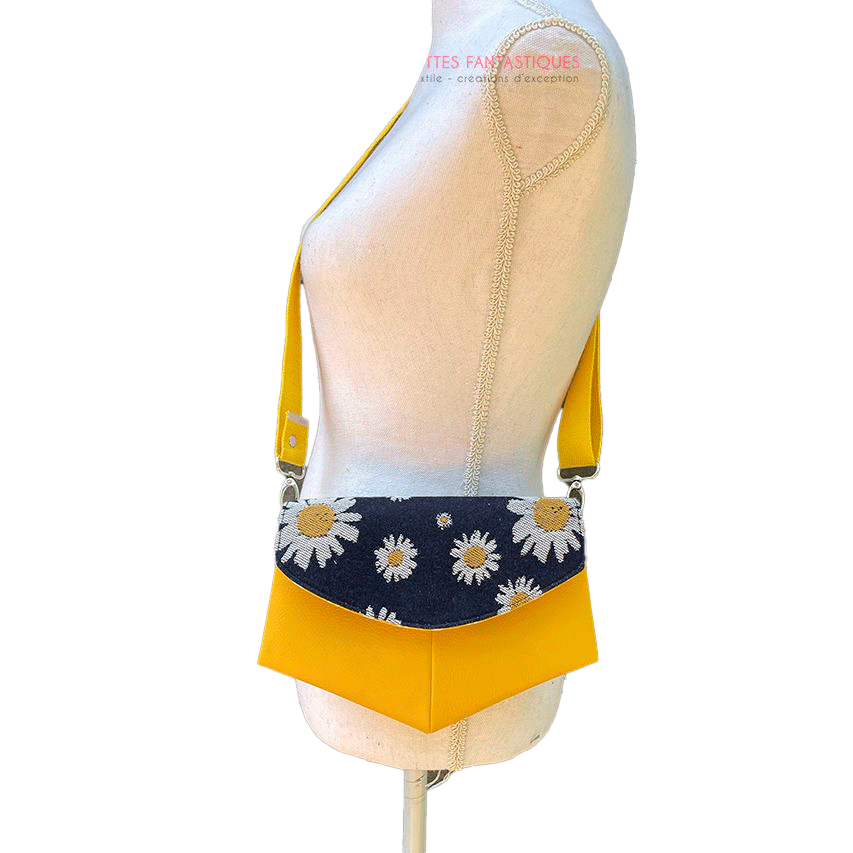 A small bag made from yellow faux leather and a fabric coupon with white and yellow daisies on a navy blue background.