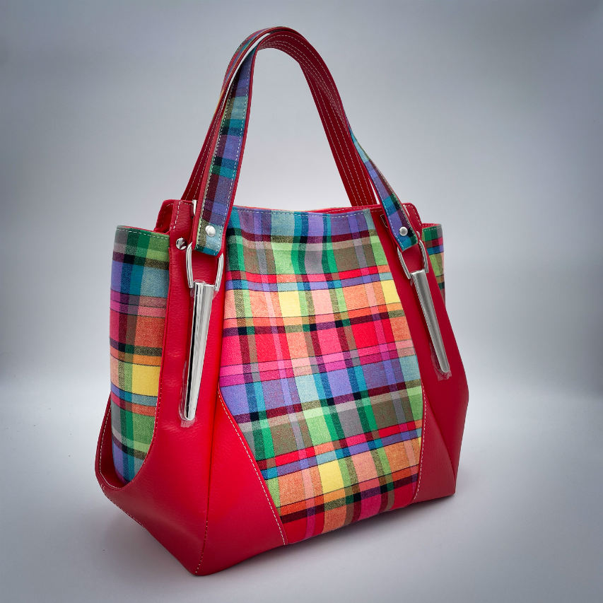 A shoulder bag made of blood-red faux leather and multicolored madras fabric.