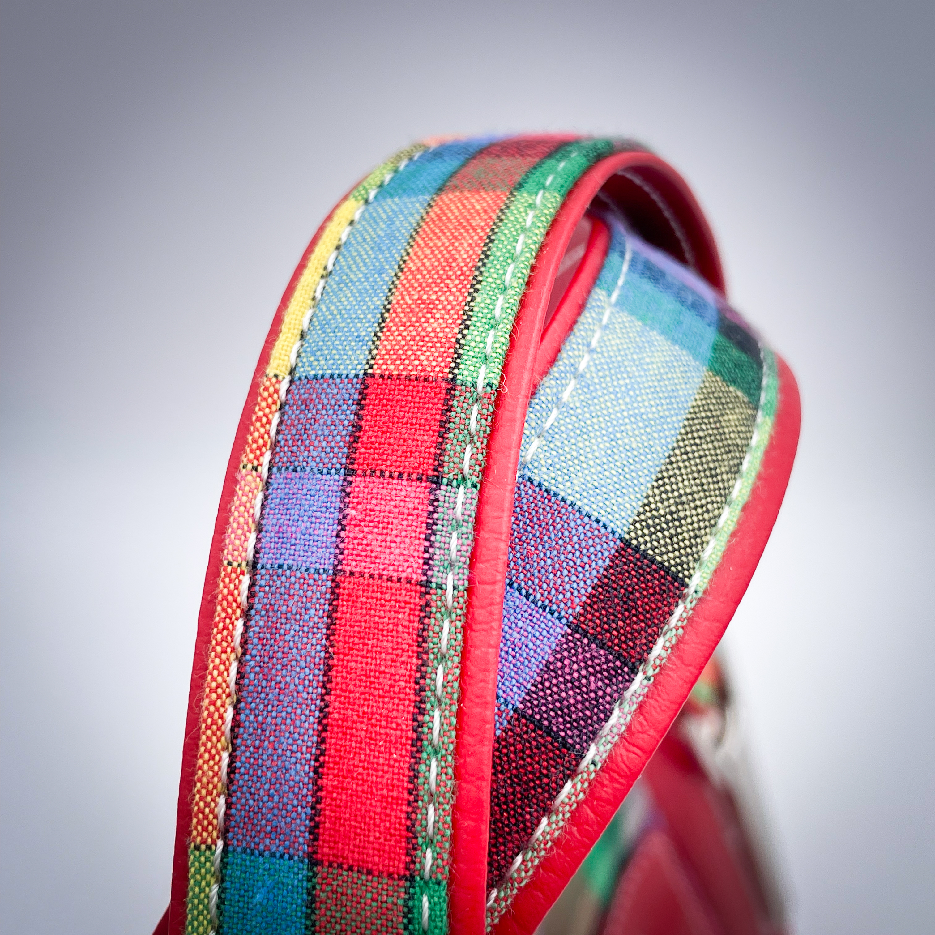 A shoulder bag made of blood-red faux leather and multicolored madras fabric.