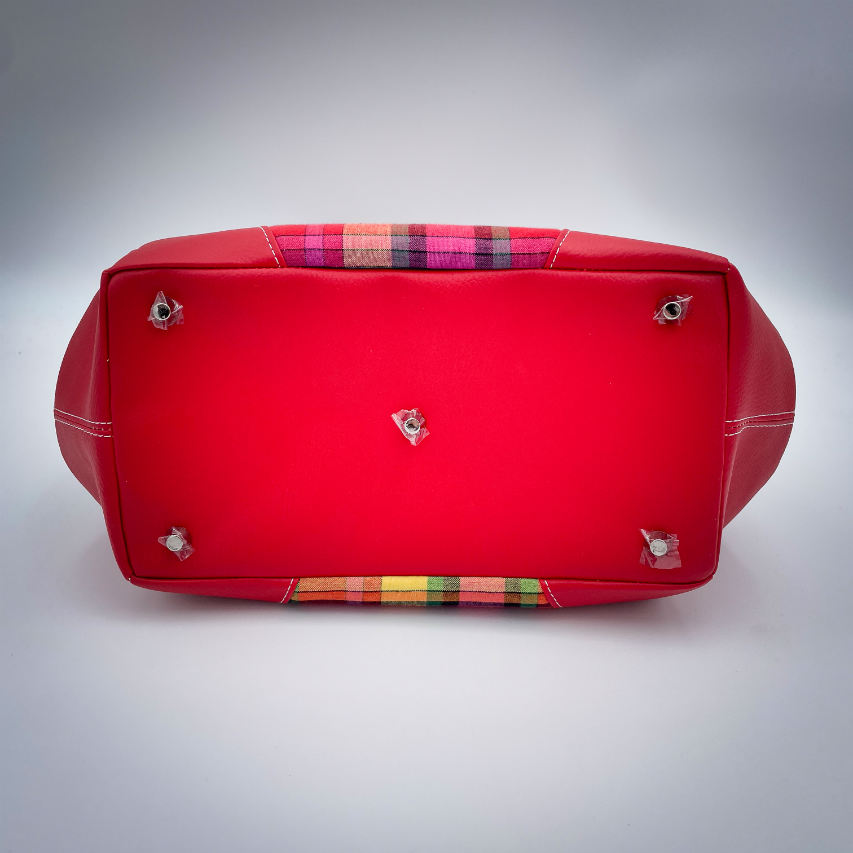 A shoulder bag made of blood-red faux leather and multicolored madras fabric.