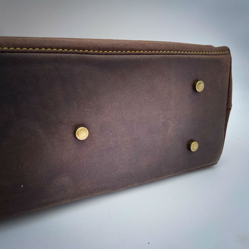 A shoulder bag made from chocolate and yellow leathers combined with a floral canvas featuring pink and yellow flowers.