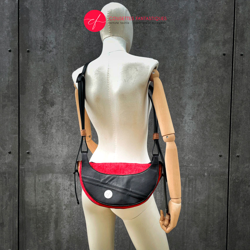 A shoulder bag made of black and caramel leathers, red and black velvet upholstery fabric, and red and black satins.