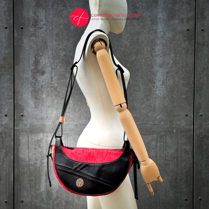 A shoulder bag made of black and caramel leathers, red and black velvet upholstery fabric, and red and black satins.