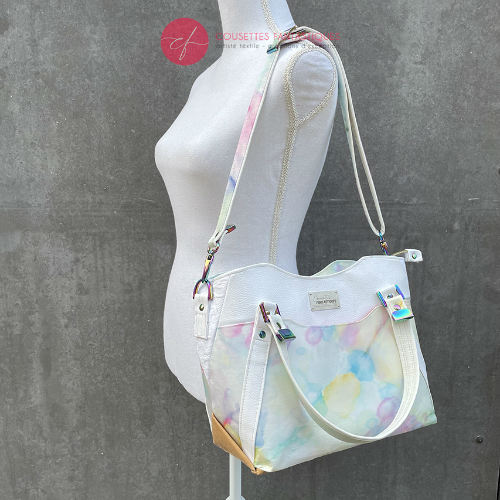 A shoulder bag made from various materials: white synthetic material, hand-painted silk scarf, and white cotton damask.