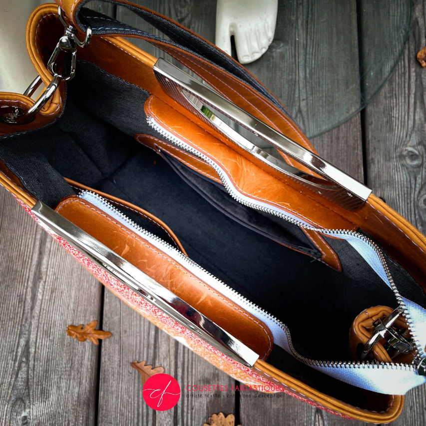 A shoulder bag made of caramel cowhide leather and a gradient-colored babywearing wrap with motivational texts and icons in white.