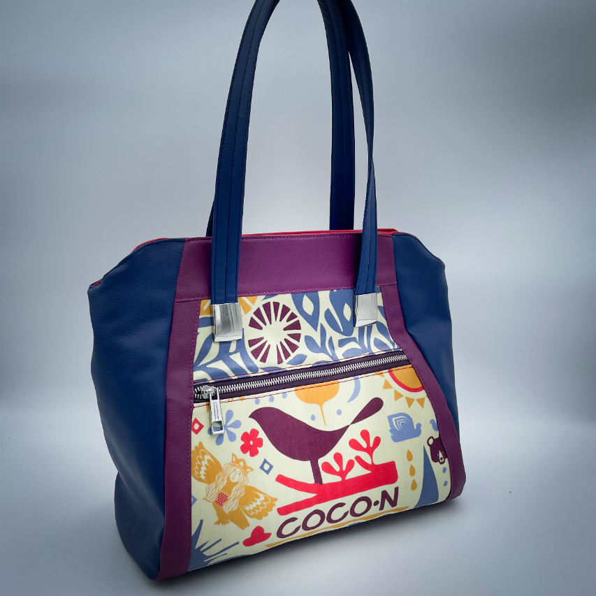 A shoulder bag made from a silk scarf with Scandinavian folklore patterns, combined with red, blue, and purple faux leathers.