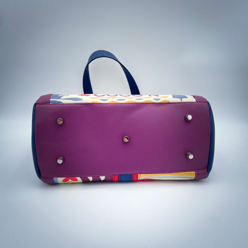 A shoulder bag made from a silk scarf with Scandinavian folklore patterns, combined with red, blue, and purple faux leathers.