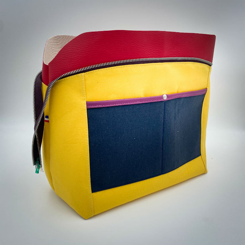 A shoulder bag made from a silk scarf with Scandinavian folklore patterns, combined with red, blue, and purple faux leathers.