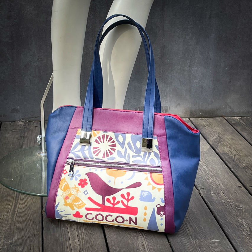 A shoulder bag made from a silk scarf with Scandinavian folklore patterns, combined with red, blue, and purple faux leathers.