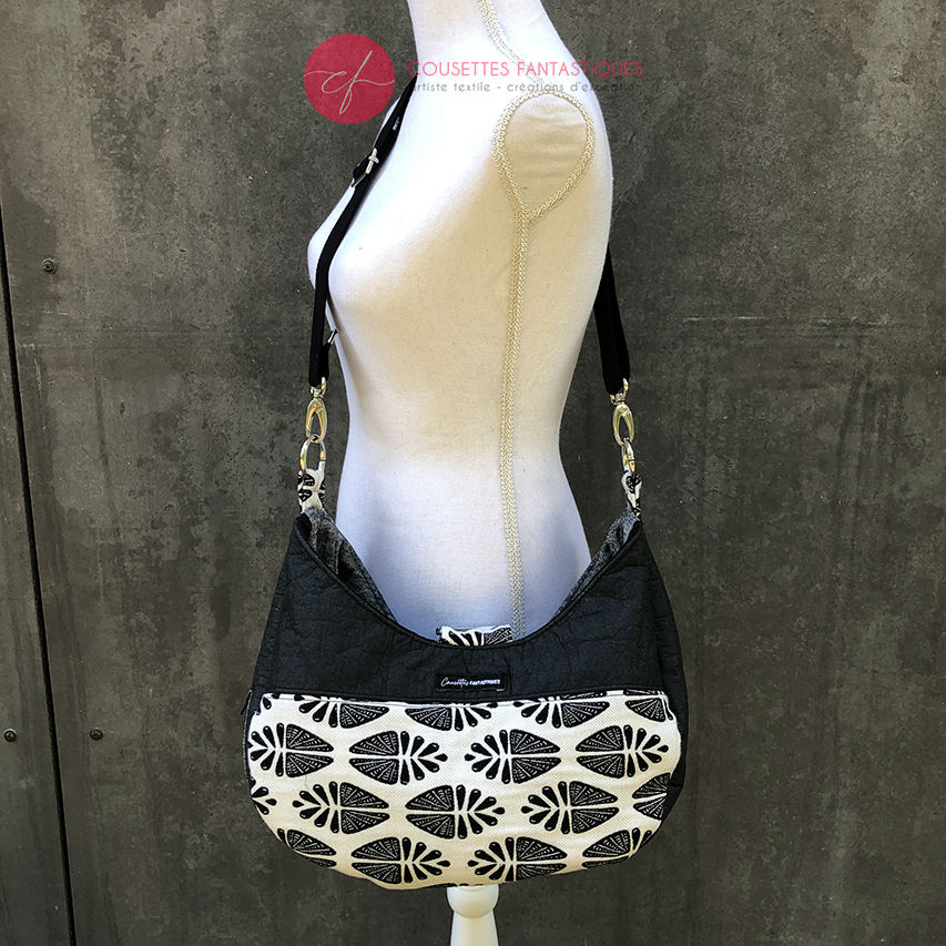 Un sac d'épaule fait avec du tissu d'écharpe dégradé de jaune orangé à rose, au motif motif étoiles pointillistes, et du simili blanc.