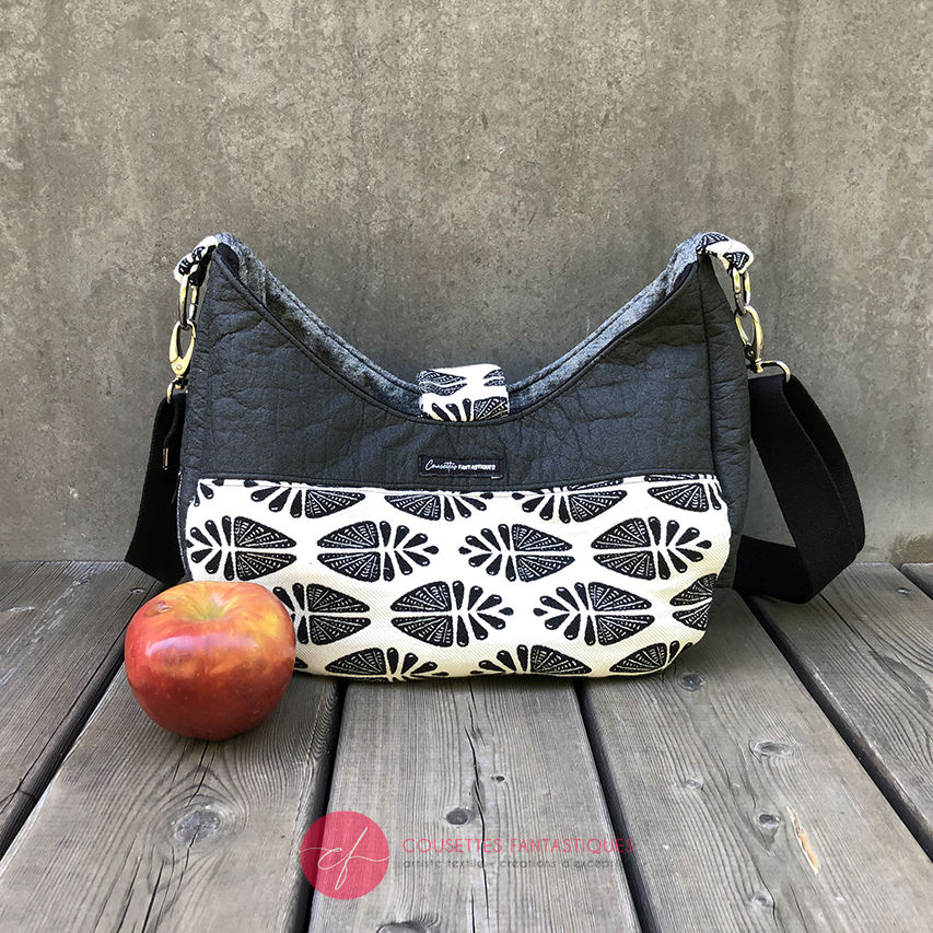 Un sac d'épaule fait avec du tissu d'écharpe dégradé de jaune orangé à rose, au motif motif étoiles pointillistes, et du simili blanc.