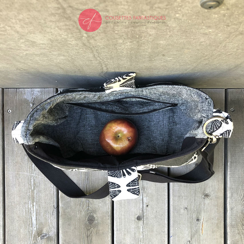 Un sac d'épaule fait avec du tissu d'écharpe dégradé de jaune orangé à rose, au motif motif étoiles pointillistes, et du simili blanc.