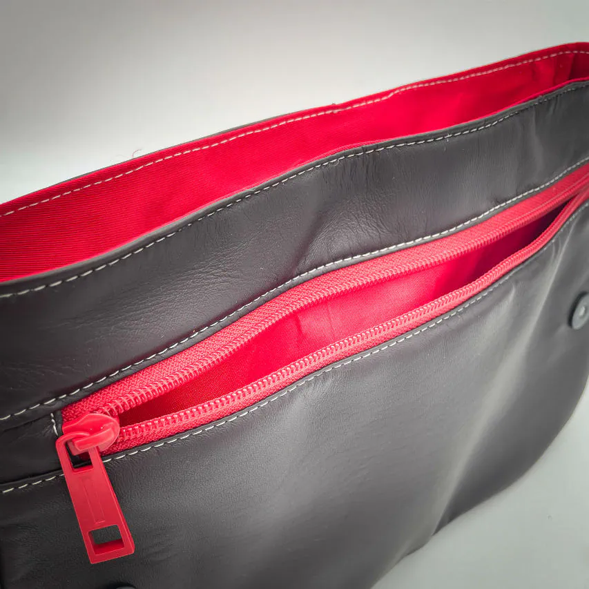 A shoulder bag made of leathers in different shades of red, with brown accents and a red lining.