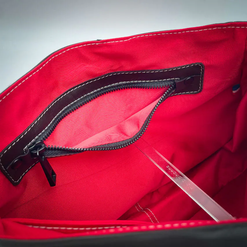 A shoulder bag made of leathers in different shades of red, with brown accents and a red lining.