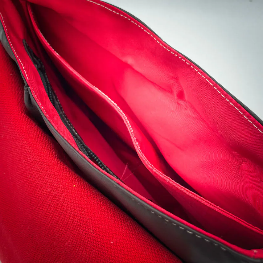 A shoulder bag made of leathers in different shades of red, with brown accents and a red lining.