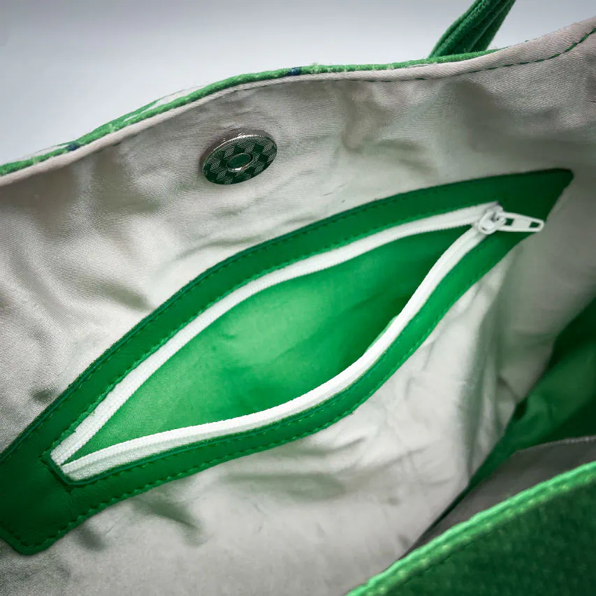 A shoulder bag in white and green leathers combined with a vintage green-and-white football jersey, and a white-and-green polyester satin lining.