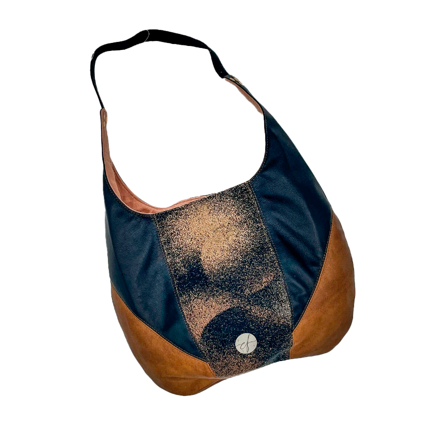 A shoulder bag made of brown and black leathers, a black, brown, and beige babywearing wrap with a round abstract pattern, and peach linen canvas.