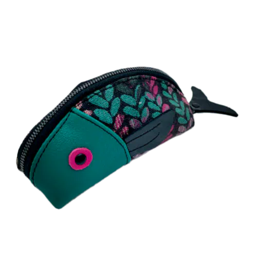 A zippered pouch sewn from sage green leather, black patent leather, fuchsia pink leather, and two scraps of a babywearing wrap with a green, beige, and pink mesh pattern on a black background.