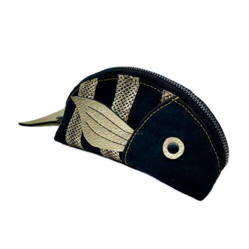 A zippered pouch sewn with black cork, black voile with golden stripes, and golden metallic leather.