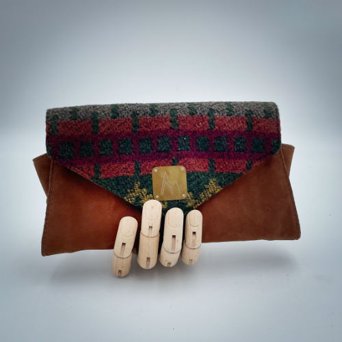 A wallet made from chestnut faux suede and geometric-patterned wool fabric, with a viscose lining featuring a geometric print.