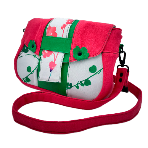 A crossbody bag made from floral-patterned neoprene, fuchsia pink crepe, and vivid green grained leather.