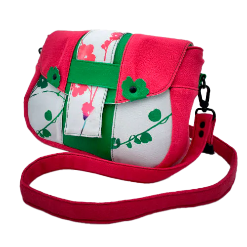A crossbody bag made from floral-patterned neoprene, fuchsia pink crepe, and vivid green grained leather.