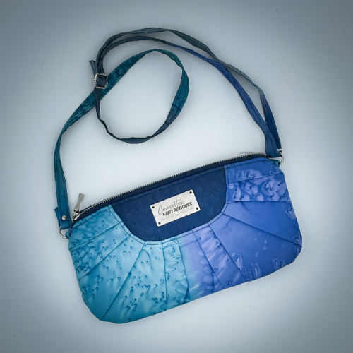 A zippered pouch sewn from a silk scarf in shades of blue, pleated and combined with royal blue cork.