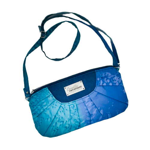 A zippered pouch sewn from a silk scarf in shades of blue, pleated and combined with royal blue cork.
