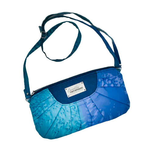 A zippered pouch sewn from a silk scarf in shades of blue, pleated and combined with royal blue cork.