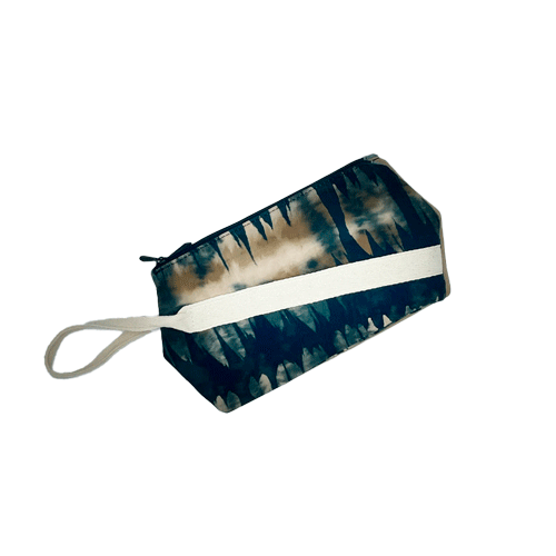 A double-zippered pouch sewn from beige synthetic suede and a fabric with abstract motifs in forest green, beige, and fawn tones, lined with almond green poplin.