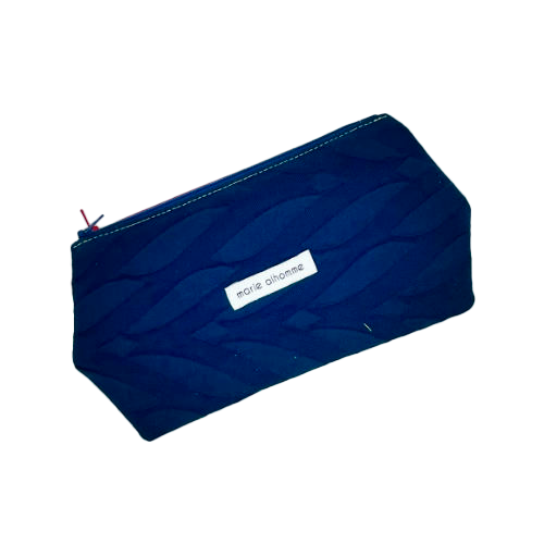 A double zippered pouch sewn from several babywearing wrap scraps (blue and red) and white faux leather.