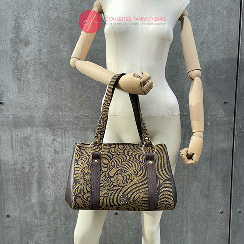 A handbag made of brown synthetic leather and brown and fawn babywearing wrap fabric with a stylized tiger pattern.