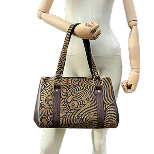 A handbag made of brown synthetic leather and brown and fawn babywearing wrap fabric with a stylized tiger pattern.