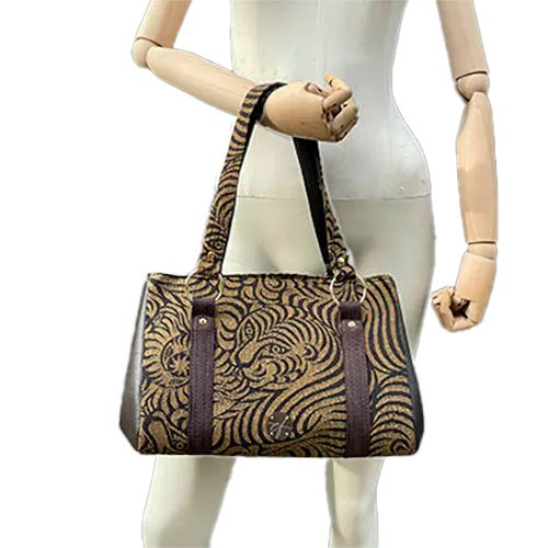 A handbag made of brown synthetic leather and brown and fawn babywearing wrap fabric with a stylized tiger pattern.