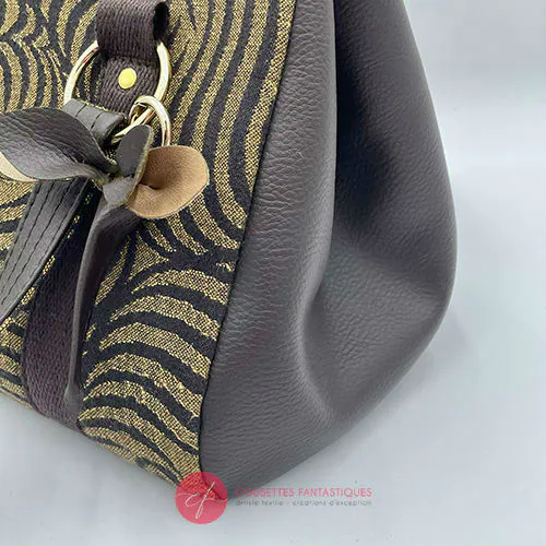 A handbag made of brown synthetic leather and brown and fawn babywearing wrap fabric with a stylized tiger pattern.