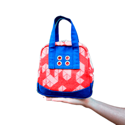 A mini handbag made of orange babywearing wrap fabric with a white geometric pattern, and blue Klein workwear fabric.