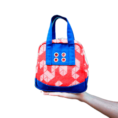A mini handbag made of orange babywearing wrap fabric with a white geometric pattern, and blue Klein workwear fabric.