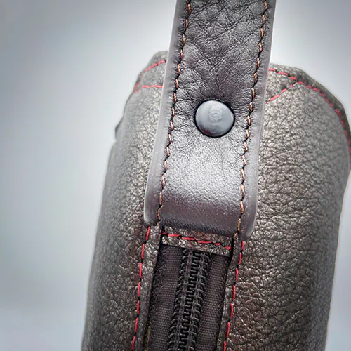 A handbag made of metallic leather with an iridescent red satin lining.