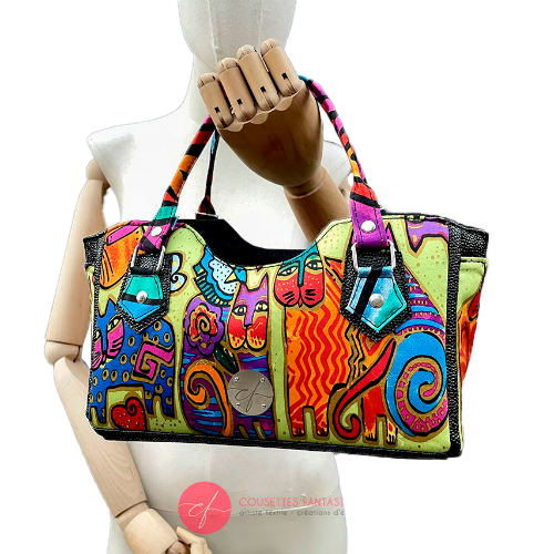 A small handbag made of shiny black faux galuchat texture and a silk scarf with a very colorful cat motif.
