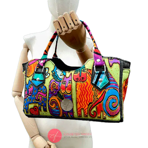 A small handbag made of shiny black faux galuchat texture and a silk scarf with a very colorful cat motif.