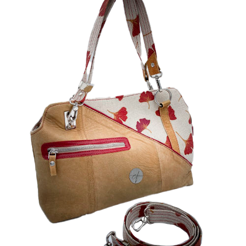 A handbag made of camel colored leather and a red Ginkgo Biloba leaves patterned polycotton canvas.