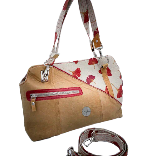 A handbag made of camel colored leather and a red Ginkgo Biloba leaves patterned polycotton canvas.