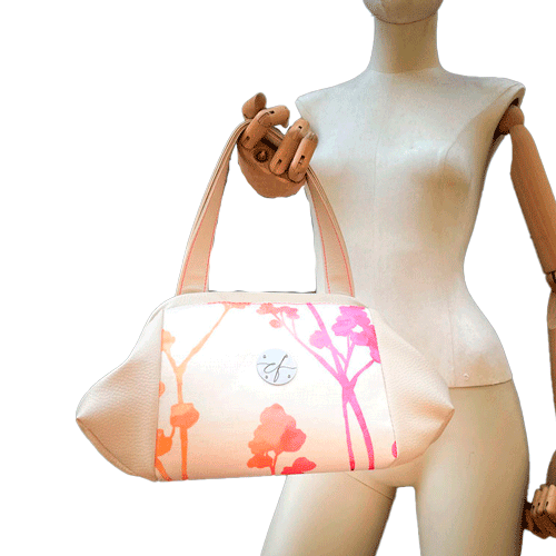 A handbag made of cream synthetic upholstery fabric and cream faux leather, featuring a gradient botanical pattern from pink to orange.