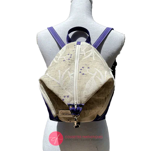 A backpack sewn in royal blue canvas and wax fabric in blue, brown-red, black, and white tones.
