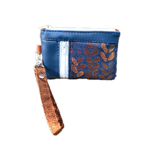 A mini zippered coin purse made up of a patchwork of different materials: royal blue faux leather, golden faux leather, shiny bronze fabric, and blue and bronze wrap fabric with a pattern of small droplets.